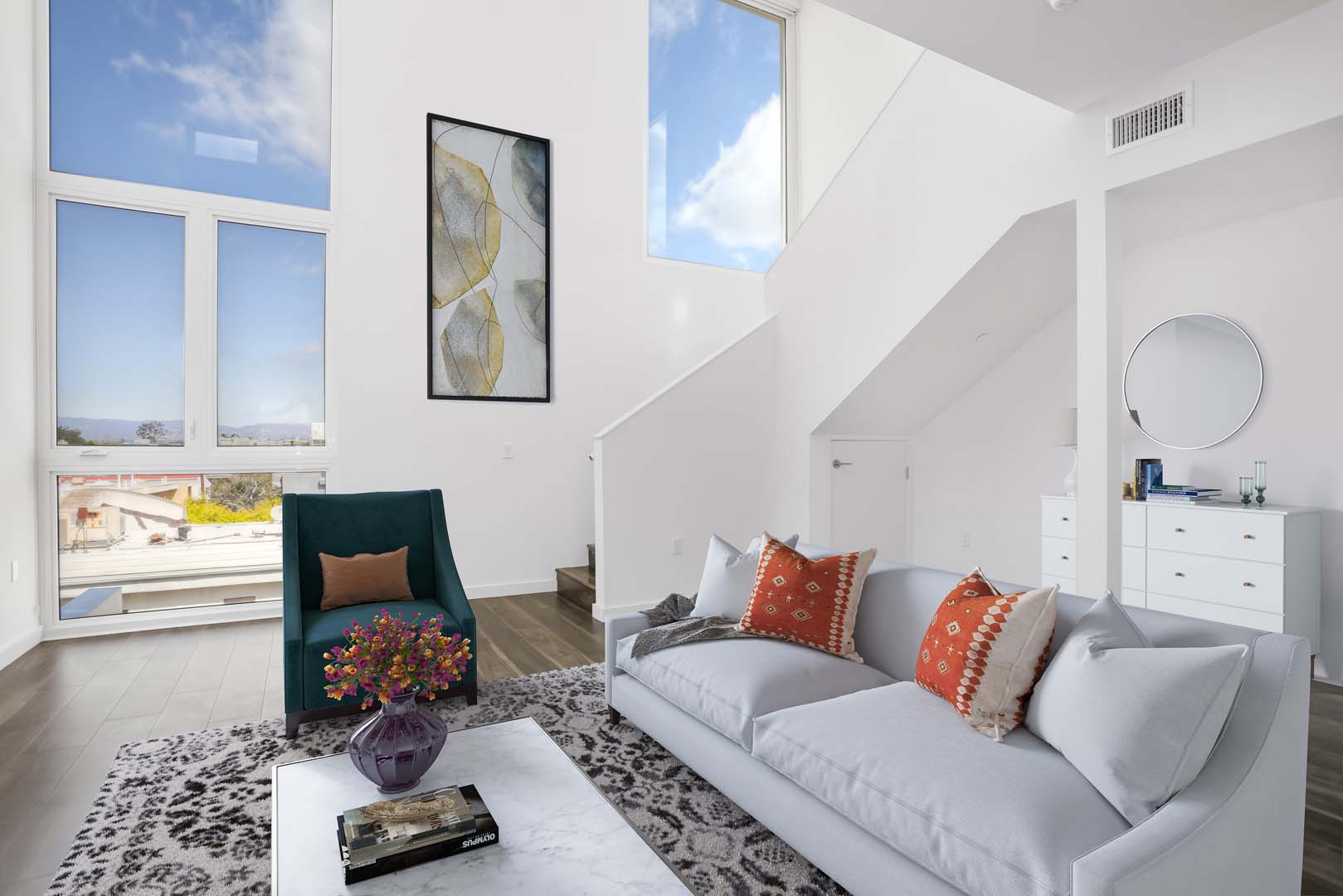 Culver City CA Luxury Apartments - Open Space Living Room with Hardwood Floors and Stylish Interior Featuring Large Windows and Staircase Leading to Second Floor