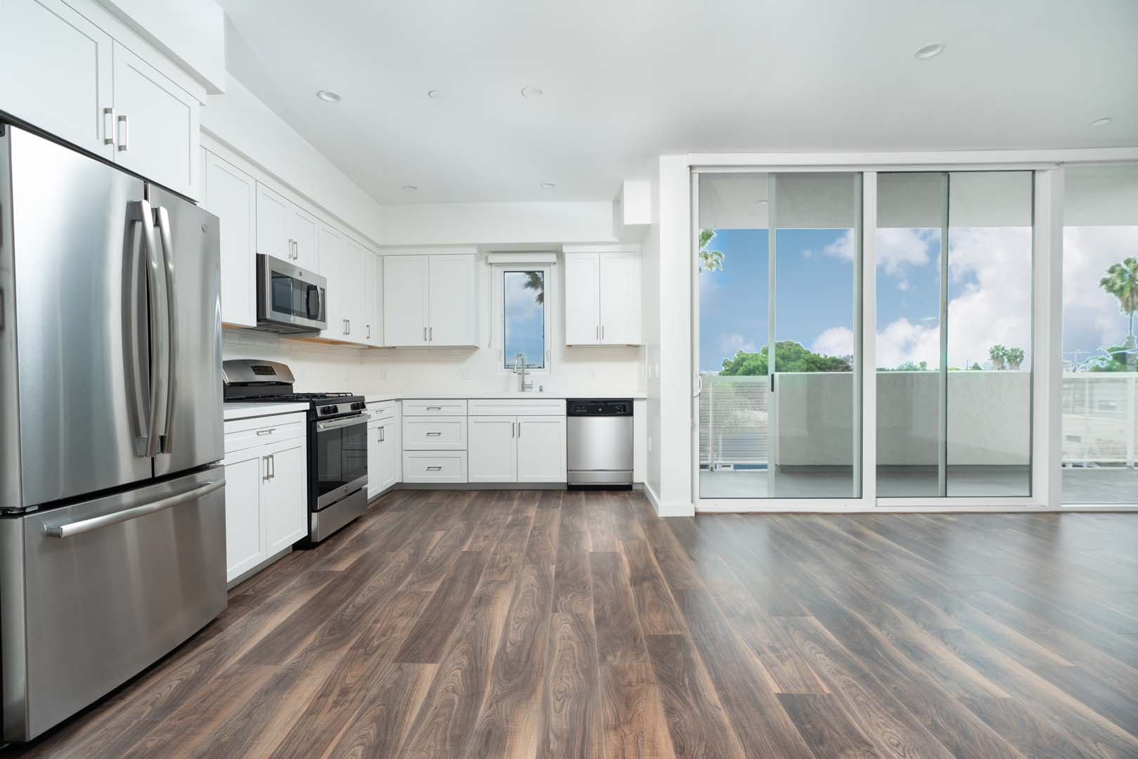 Apartments for Rent Culver City - The Lucky - Large Kitchen Space with Stainless Steel Appliances, Hardwood Floors, and Large Glass Sliding Door